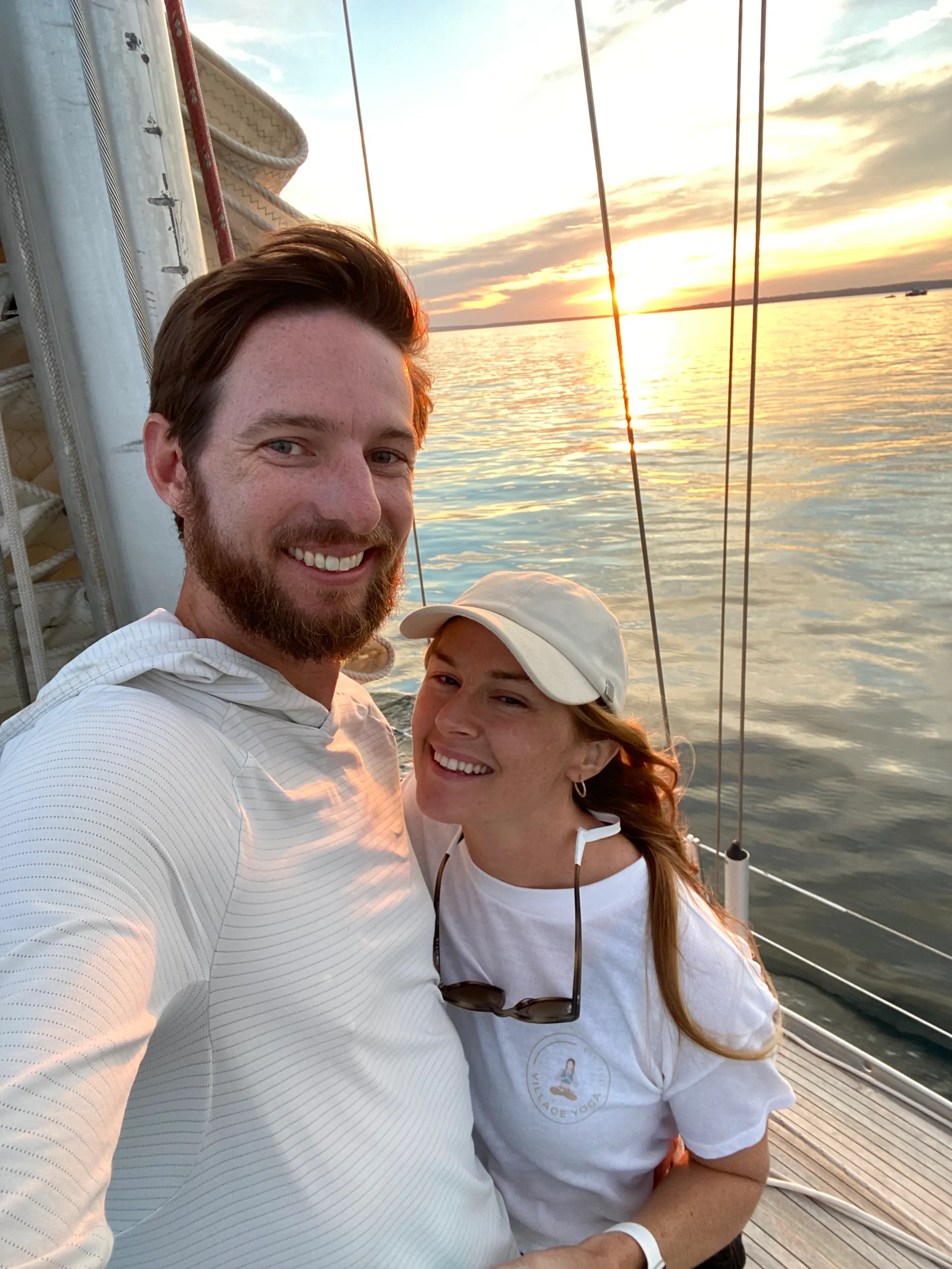 Emily and Justin, co-founders of Windward Vessel Care, aboard a sailboat at sunset on Florida's Treasure Coast